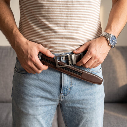 Homme qui ajuste sa ceinture en cuir marron foncé sur un jean